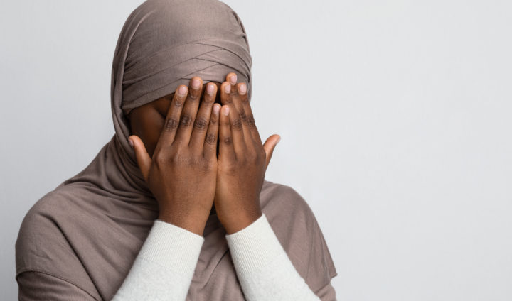 Closeup Shot Of Black Muslim Woman In Hijab Covering Face With Hands